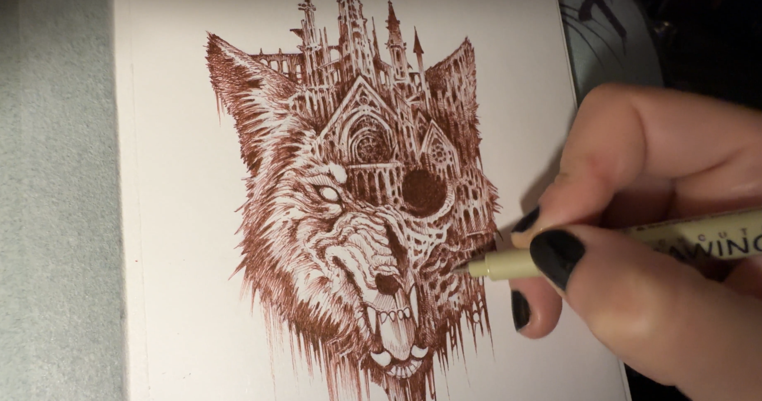 Artist Lisa Mitrokhin doodling a Castle Wolf in her journal with a brown fineliner.